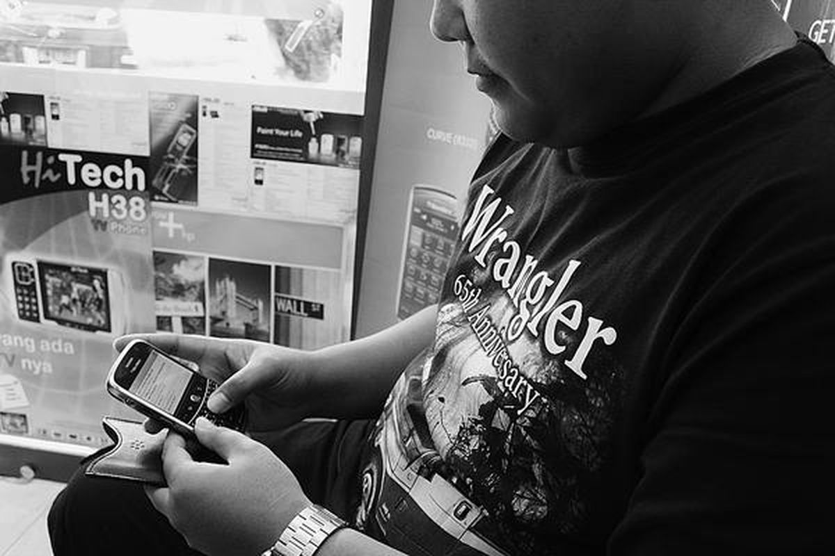 Seorang warga Palembang membaca surat elektronik menggunakan Blackberry, Jumat (6/2). Penggunaan Blackberry di Palembang sedang menjadi tren dan mampu menggeser tren smart phone maupun PDA phone.  