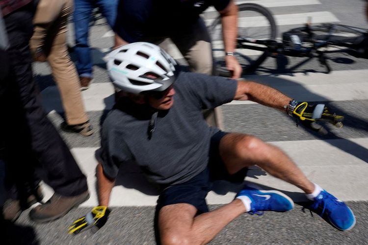Presiden AS Joe Biden jatuh ke tanah setelah menunggangi anggota masyarakat saat bersepeda di Pantai Rehoboth, Delaware, AS, 18 Juni 2022. 