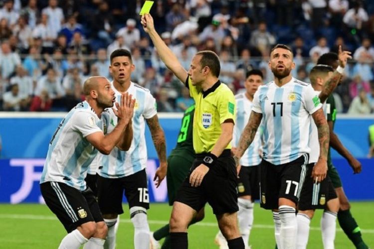 Wasit Cuneyt Cakir memberi kartu kuning kepada Javier Mascherano yang melakukan pelanggaran di kotak penalti Argentina kepada pemain Nigeria di Stadion Krestovsky, 26 Juni 2018. 
