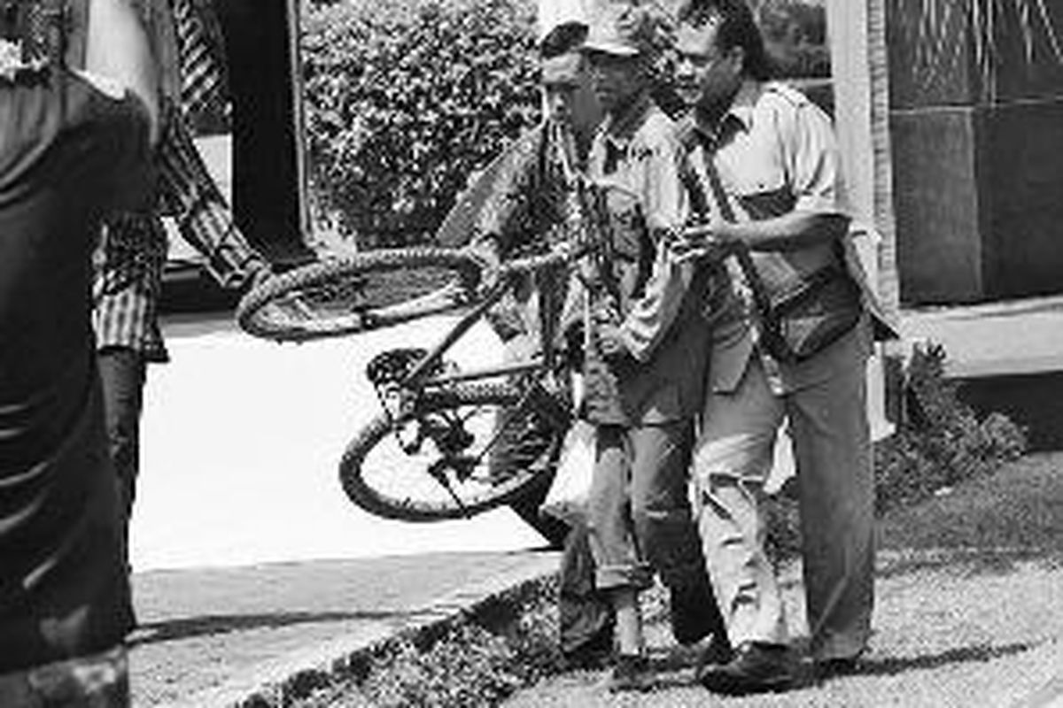 Dua petugas keamanan menggiring tukang kebun, I Nyoman Minta, saat berlangsungnya atraksi Aerobatik Jupiter pada pembukaan ASEAN Fair 2011 yang disaksikan Presiden Susilo Bambang Yudhoyono di Nusa Dua, Bali, Senin (24/10). Tukang kebun tersebut lolos dari pengawasan petugas keamanan ketika Presiden Yudhoyono dan tamu undangan menyaksikan atraksi pesawat terbang.