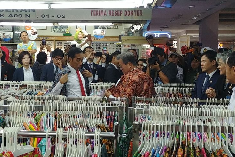 Presiden Joko Widodo dan Presiden Korsel Moon Jae-in menjajal batik di salah satu toko di Bogor Trade Mall di Bogor, Jawa Barat, Kamis (9/11/2017).