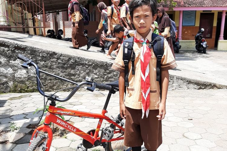 Rehan bersama hadiah sepeda dari sang guru Anys Susilo dari SDN 2 Pokoh Kidul, Wonogiri, Jawa Tengah,  