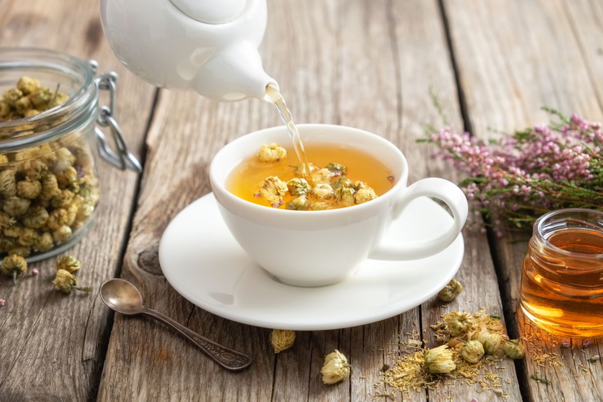 Ilustrasi menuangkan teh chamomile.