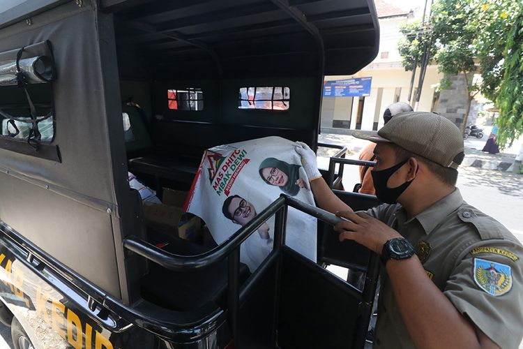 Petugas Satuan Polisi Pamong Praja mengamankan poster alat peraga kampanye (APK) Pilkada Kediri ke dalam mobil, di Kediri, Jawa Timur, Rabu (7/10/2020). Sejumlah APK yang menyalahi aturan ditertibkan seperti yang dipasang di jalan protokol, tempat ibadah dan tempat pendidikan.