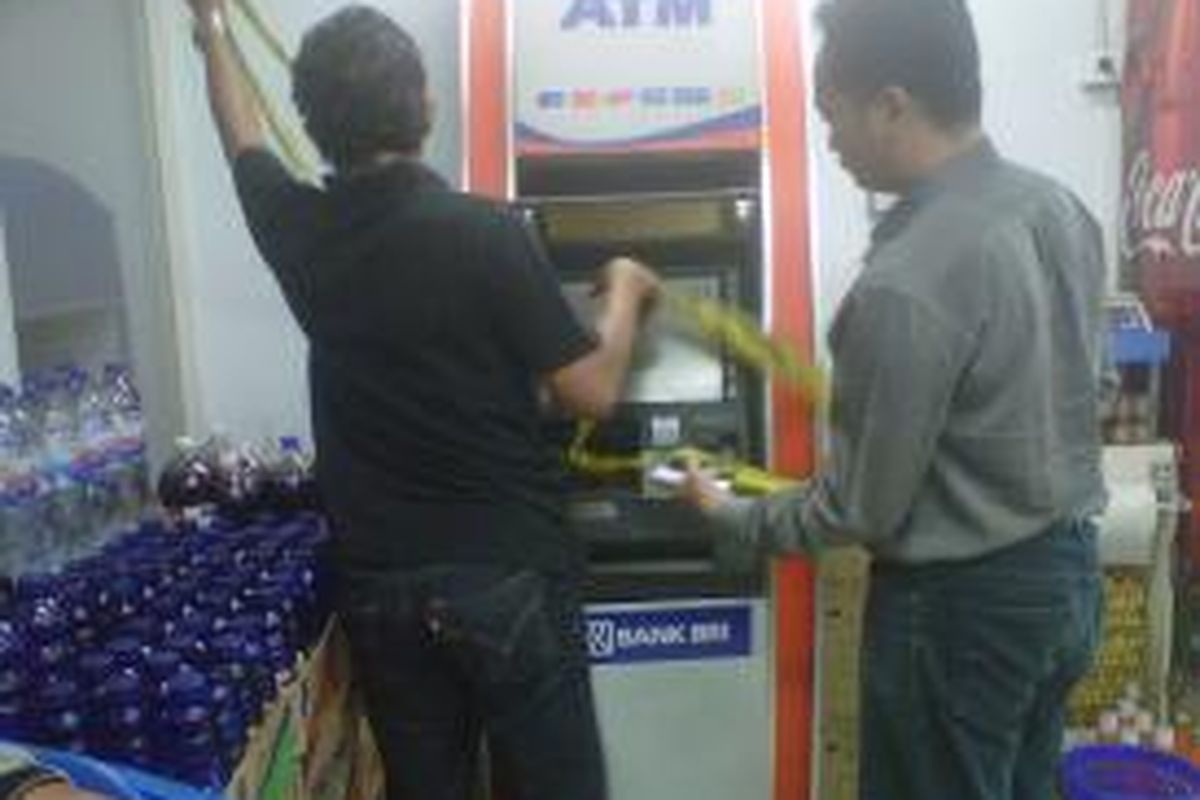 Tim penyidik dari Kepolisian Jakarta Utara sedang memeriksa mesin ATM yang dibobol menggunakan las di salah satu mini market di Semper Barat, Cilincing, Jakarta Utara.