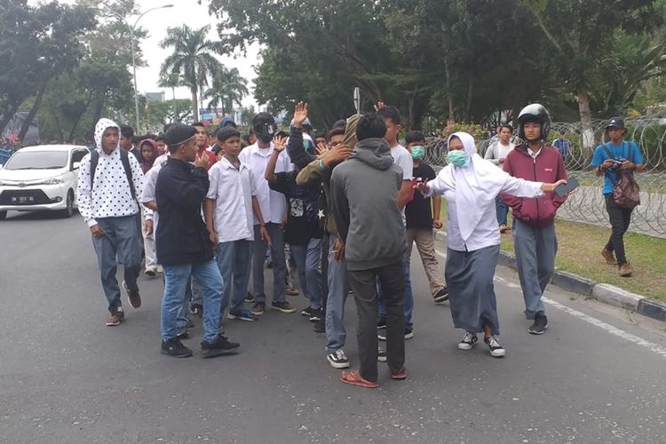 Ratusan siswa SMA dan SMK yang ikut bergabung demo dengan mahasiswa di Kantor DPRD Riau di Jalan Jenderal Sudirman, Kota Pekanbaru, Riau, Senin (30/9/2019).