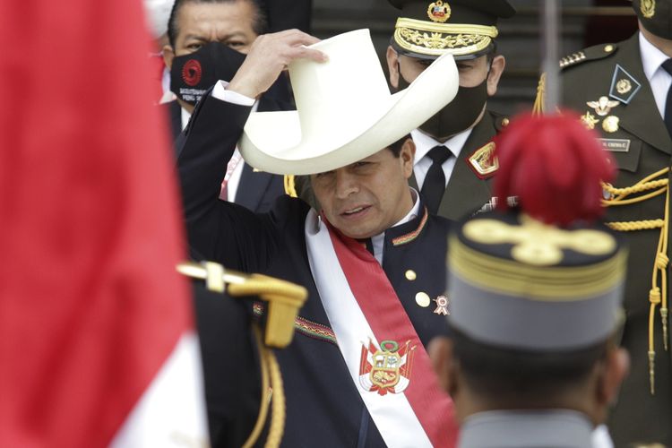 Presiden Peru yang baru, Pedro Castillo, memakai topinya lagi setelah melepasnya saat prosesi sumpah jabatan pada hari pelantikan di Lima, ibu kota Peru, Rabu (28/7/2021). Castillo adalah guru desa yang populer berkat slogan Tak ada lagi orang miskin di negara kaya, dan membuat kejutan dengan melaju ke pemilu putaran kedua lalu menang.