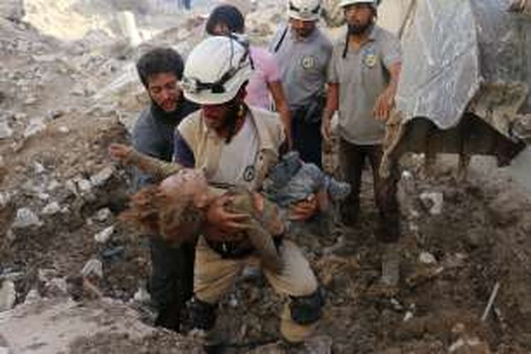 Seorang anggota kelompok sukarelawan White Helmets alias Helm Putih membopong jasad seorang anak perempuan dari reruntuhan rumahnya yang hancur dihantam bom di Aleppo, Suriah.