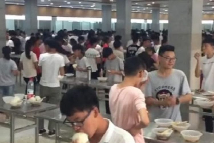 Dalam potongan gambar video di Pear, terlihat para siswa menikmati makan siang sambil berdiri. Sekolah memutuskan menyingkirkan kursi di kantin agar siswanya rajin belajar.