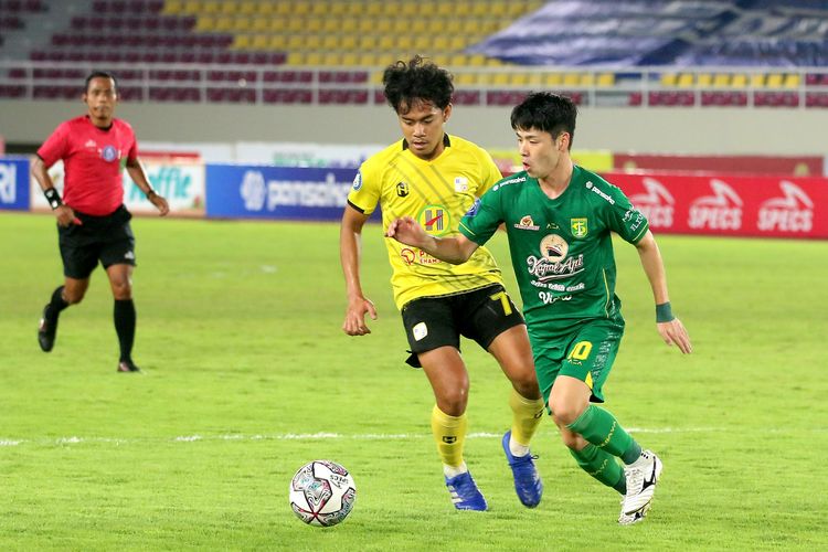 Penyerang Persebaya asal Jepang, Taisei Marukawa, terlibat perebutan bola dengan personel Barito Putera dalam laga Liga 1 2021-2022 di Stadion Manahan, Solo, Sabtu 4 Desember 2021.