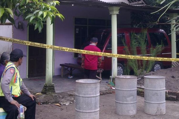 Polisi berjaga di rumah lokasi pembunuhan Sujarno di Desa Sidomulyo Kecamatan Wates, Kabupaten Kediri, Jawa Timur. (KOMPAS.com/M.Agus Fauzul Hakim).