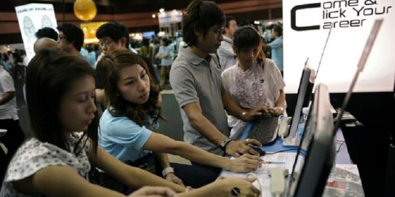 Para pencari kerja melihat iklan lowongan kerja di Bangkok, Thailand.
