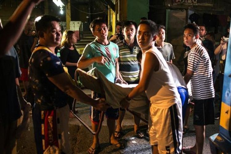 Warga Manila menggotong seorang tersangka pengedar narkoba yang tewas ditembak. Sejak Presiden Rodrigo Duterte berkuasa akhir Juni lalu, lebih dari 3.000 orang tewas dalam perang melawan narkoba.