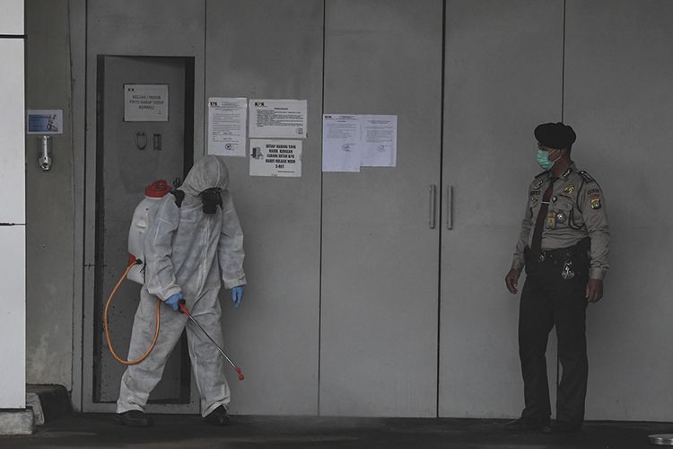 Petugas menyemprotkan cairan disinfektan di pintu masuk rumah tahanan KPK di Jakarta, Rabu (18/3/2020). Untuk mencegah penyebaran COVID-19, KPK melakukan disinfeksi di sejumlah area Gedung Merah Putih.
