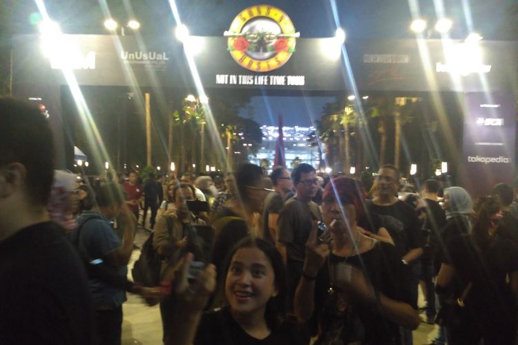 Para penonton berfoto di gapura area konser Guns N Roses sebelum memasuki area konser di Stadion Utama GBK, Senayan, Jakarta Pusat, Kamis (8/11/2018).