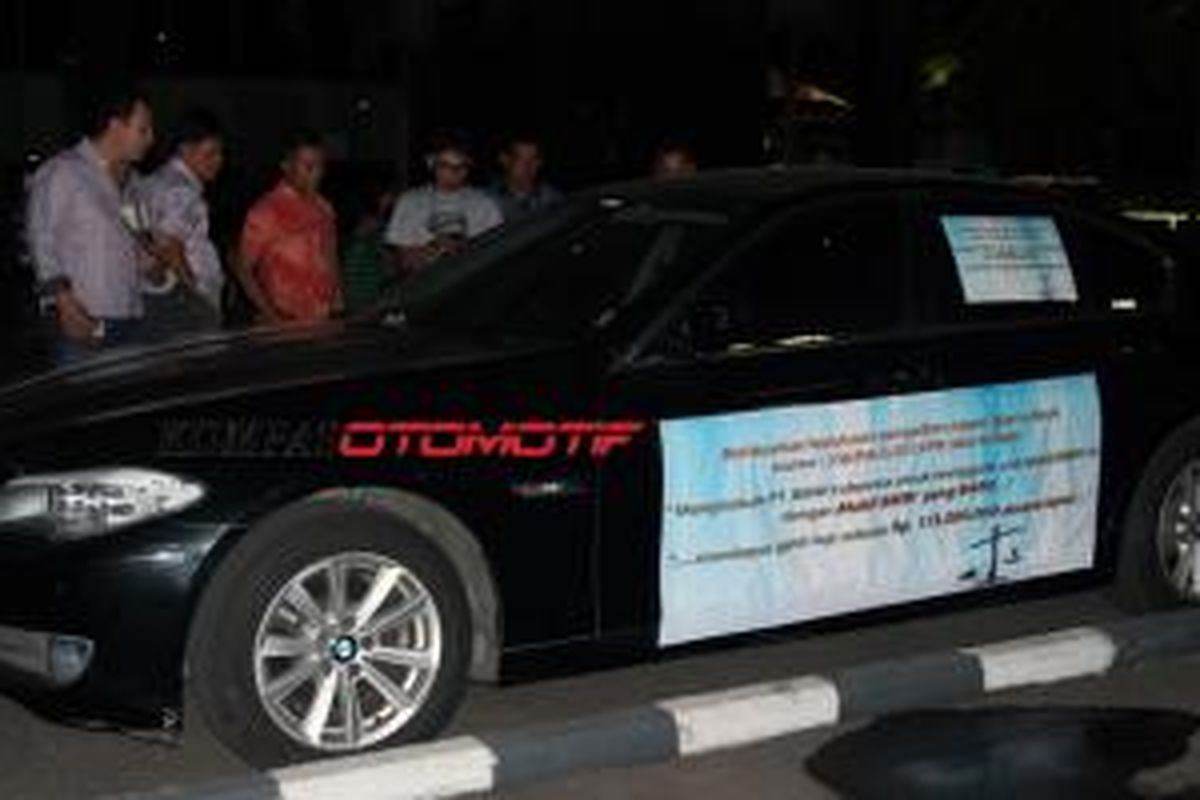 Seunit BMW 520i berkelir hitam terlihat parkir di depan lobi  Gedung Pusat Niaga, JiExpo Kemayoran, Jakarta Pusat, Jumat (26/9/2014). Pada sebagian besar bodi terdapat pernyataan yang menyinggung PT BMW Indonesia. 