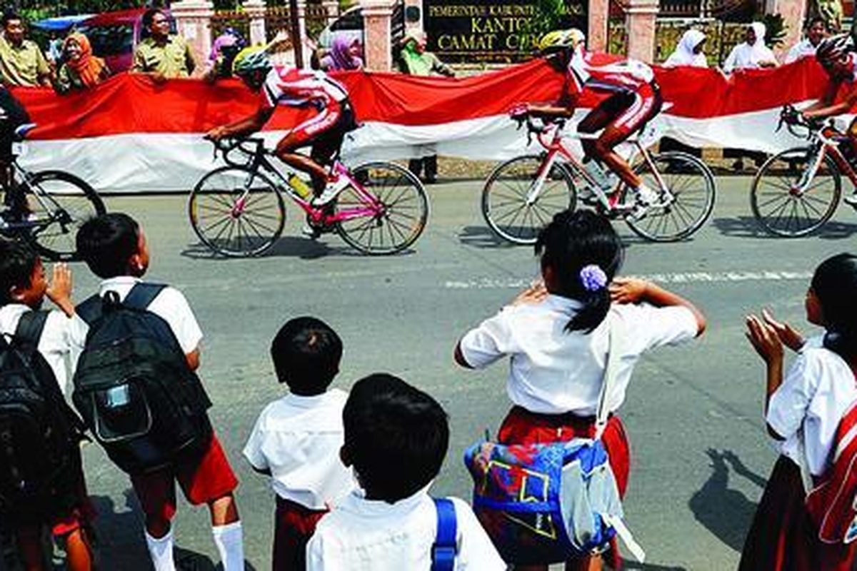 Tim balap sepeda Indonesia disambut warga saat melintasi jalanan Cibogo, Subang, Jawa Barat, dalam laga nomor 70 kilometer team time trial putra  SEA Games XXVI, Selasa (15/11). Pada nomor ini, tim Thailand meraih emas, sedangkan perak dan perunggu diraih  Indonesia dan Filipina.