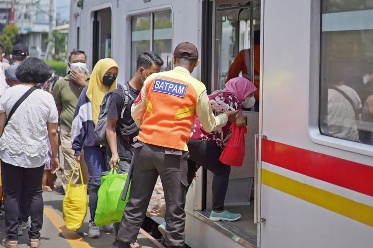 Ilustrasi petugas pengamanan stasiun membantu pengguna commuter line.