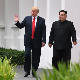 Pemimpin Korea Utara Kim Jong Un (kanan) berjalan bersama Presiden AS Donald Trump pada pertemuan bersejarah antara AS-Korea Utara, di Hotel Capella di Pulau Sentosa, Singapura, Selasa (12/6/2018). Pertemuan ini merupakan yang pertama kalinya bagi pemimpin kedua negara dan menjadi momentum negosiasi untuk mengakhiri kebuntuan permasalahan nuklir yang telah terjadi puluhan tahun.