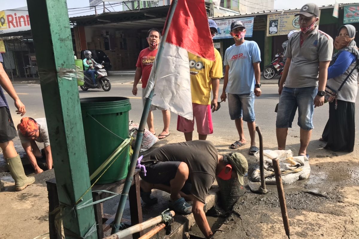 Sejumlah warga di RW 10, Kelurahan Mampang, Pancoran Mas, Kota Depok, Jawa Barat, Senin (17/8/2020), bergotong royong melakukan kerja bakti untuk mengatasi air yang kerap meluap di perempatan Krukut Mampang saat hujan. 