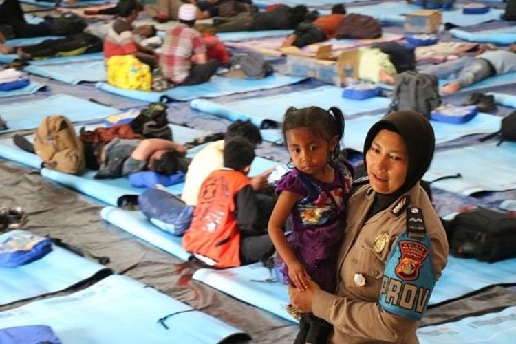 Seorang polisi wanita bermain dengan anak pengungsi Wamena di pengungsian di kota Merauke, Papua (03/10). 