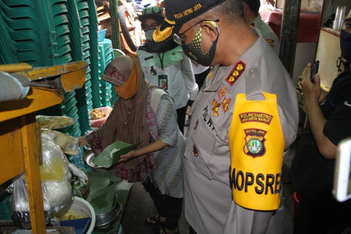 Kapolres Metro Jakarta Barat Kombes Pol Audie S Latuheru saat membagikan paket sembako pada warga di wilayah Tanah Sereal, Tambora, Jakarta Barat, Rabu (29/4/2020)