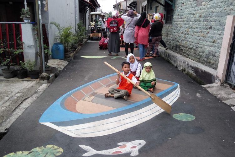 Warga saat berfoto di atas lukisan tiga dimensi di Jalan Danau Tondano Raya, Depok, Rabu (25/10/2017).