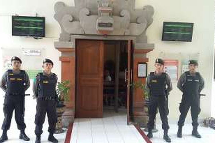 Polisi bersenjata laras panjang siaga di deoan ruang sidang perkara pembunuhan Engeline di PN Denpasar. 