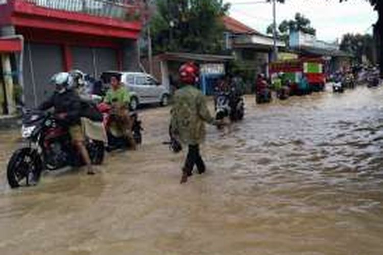 Salah satu ruas Jalan Raya di depan Desa Sumput, Kecamatan Driyorejo, Gresik, yang tergenang banjir, Senin (10/10/2016).