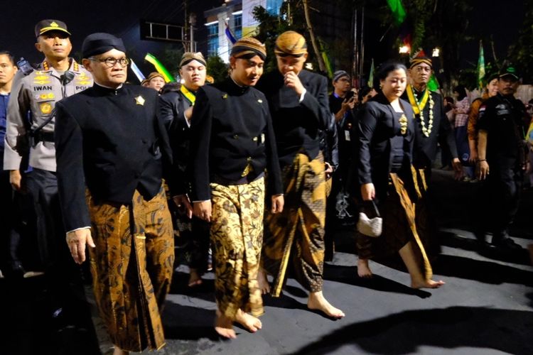 Momen Ganjar Pranowo berbisik ke Gibran Rakabuming Raka saat Malam 1 Sura di Pura Mangkunegaran Solo, Jawa Tengah (Jateng) pada Selasa (18/7/2023).