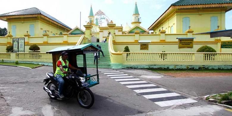 Becak motor melintas di Masjid Raya Sultan Riau atau dikenal sebagai Masjid Penyengat di Tanjung Pinang, Kepulauan Riau. Untuk berkeliling Pulau Penyengat, alternatif transportasi utama adalah becak motor. 