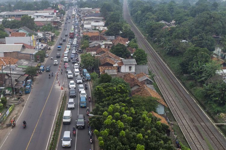 Foto udara sejumlah kendaraan pemudik melaju di jalur Pantura Karawang, Simpang Jomin, Jawa Barat, Sabtu (30/4/2022). Arus lalu lintas kendaraan pemudik melintasi jalur Pantura Karawang terpantau padat merayap pada H-2 Lebaran.