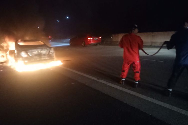 Petugas memadamkan kebakaran mobil di jalan tol Solo-Semarang.