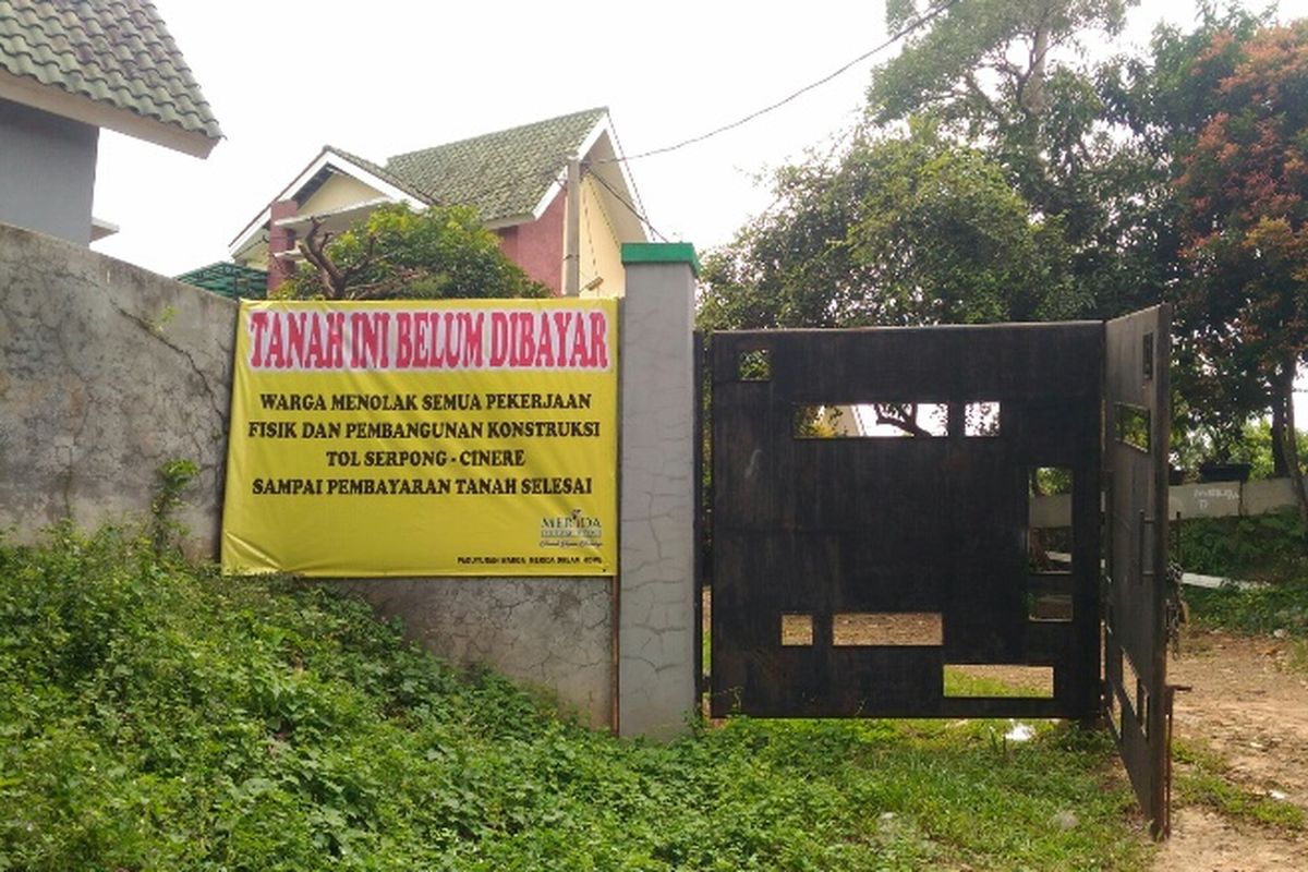 Spanduk penolakan dari Paguyuban Warga Merida Dream Home terkait pembangunan Tol JORR II Ruas Cinere-Serpong yang dipasang di bagian depan perumahan, Senin (11/12/2017).
