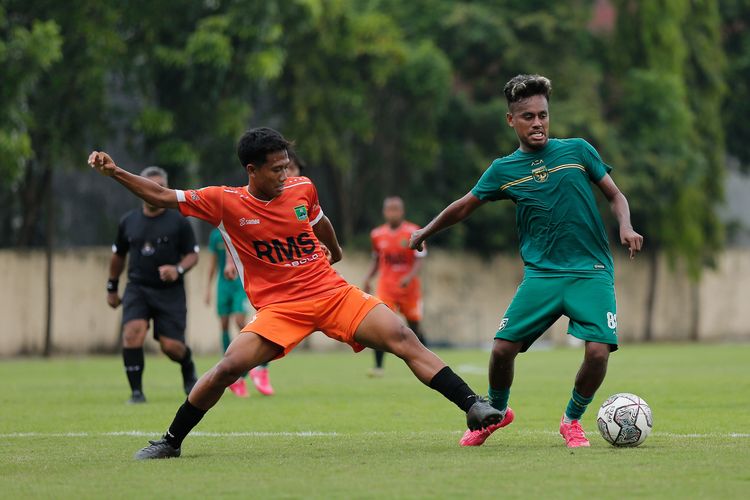 Pemain Persebaya Surabaya Alwi Slamat dijaga ketat pemain Persekabpas Kabupaten Pasuruan saat latih tanding yang berakhir dengan skor 7-1 di Lapangan Polda Jatim, Surabaya, Jumat (4/11/2022) sore.