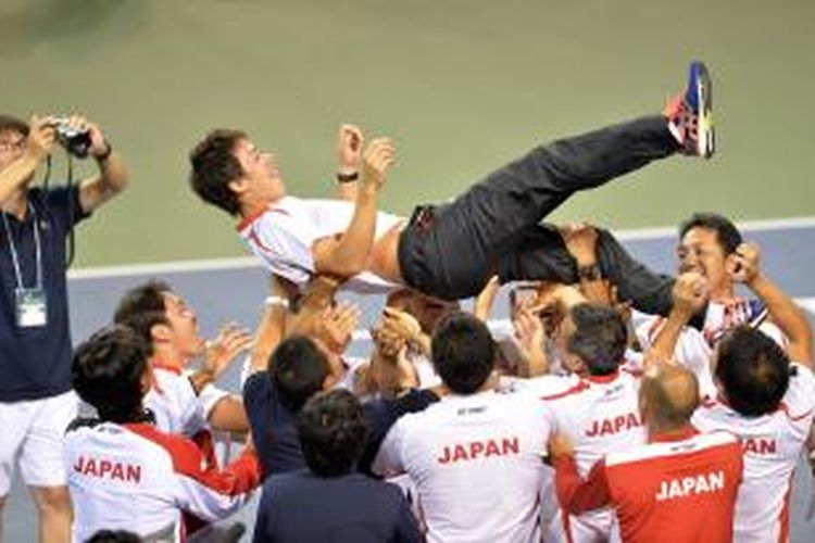 Petenis Jepang, Kei Nishikori (atas) diangkat anggota timnya, setelah Jepang memastikan diri melaju ke Grup Dunia Davis Cup, berkat kemenangan 3-2 atas Kolombia, di Tokyo, Minggu (15/9/2013).