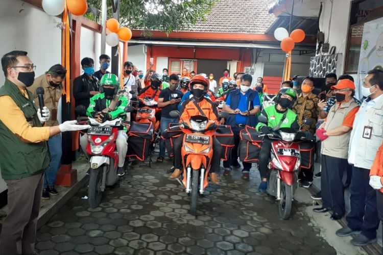 Gubernur Jawa Barat Ridwan Kamil menyerahkan bantuan paket sembako untuk warga Sumedang di PT Pos Sumedang, Sabtu (18/4/2020). AAM AMINULLAH/KOMPAS.com