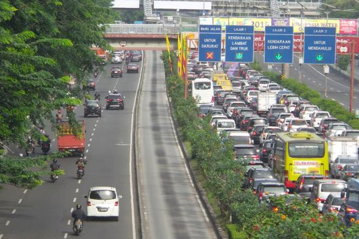 Kondisi jalan tol dalam kota (kanan) dari arah Cawang menuju Semanggi yang tengah dilanda kemacetan, Kamis (23/4/2015). Pada waktu yang sama, kondisi jalan reguler, yakni Jalan MT Haryono (kiri) justru tampak lengang. Hal ini kemungkinan besar karena sedang dilakukannya pengalihan arus di Jalan Gatot Subroto yang sedang digunakan delegasi peserta Konferensi Asia Afrika (KAA) melintas dari tempat penginapan ke lokasi tempat berlangsungnya acara di Jakarta Convention Center.