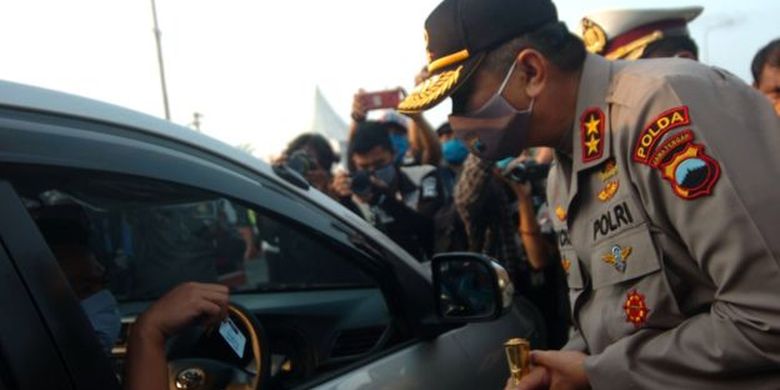 Kapolda Jateng Irjen Pol Rycko Amelza Dahniel (kanan) memperhatikan KTP pengemudi dalam penyekatan pemudik saat meninjau gerbang tol Pejagan, Brebes, Jawa Tengah, Rabu (29/4)