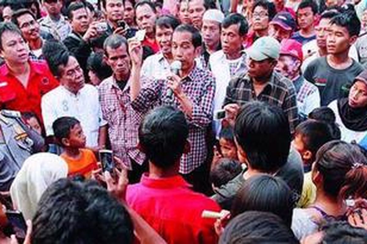 Warga antusias mendengarkan penjelasan Calon Gubernur DKI Jakarta, Joko Widodo (memegang mikrofon), saat berkampanye di perkampungan padat penduduk di Jalan Gotong Royong, Pondok Bambu, Jakarta Timur, Kamis (28/6/2012). 