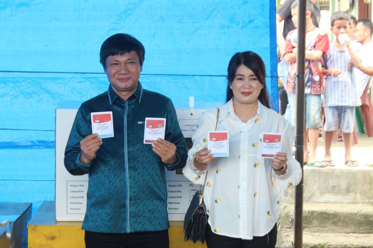 Dengan puas dab bangganya Calon Bupati Nias Eliyunus Waruwu berfoto bersama isteri usai beri hak pilih di TPS dan mengklaim menang dalam Pemilihan Bupati dan Wakil Bupati Nias Barat tahun 2024.