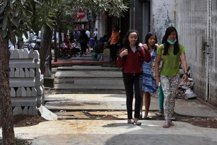 Warga berjalan di trotoar yang pengerjaannya belum selesai di Jalan Braga, Kota Bandung, Senin (5/1/2015). Pemerintah Kota Bandung melalui Dinas Bina Marga dan Pengairan Kota Bandung kembali akan melakukan lelang tender proyek trotoar di Jalan Braga dan RE Martadinata setelah memutus kontraktor sebelumnya yang tidak bisa menyelesaikan proyek tersebut. Wali Kota Bandung Ridwan Kamil berharap proyek kembali bisa dikerjakan April dan selesai Agustus 2015.