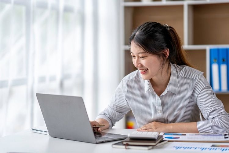 Ilustrasi seorang karyawati sedang melakukan monitoring keuangan perusahaan. 