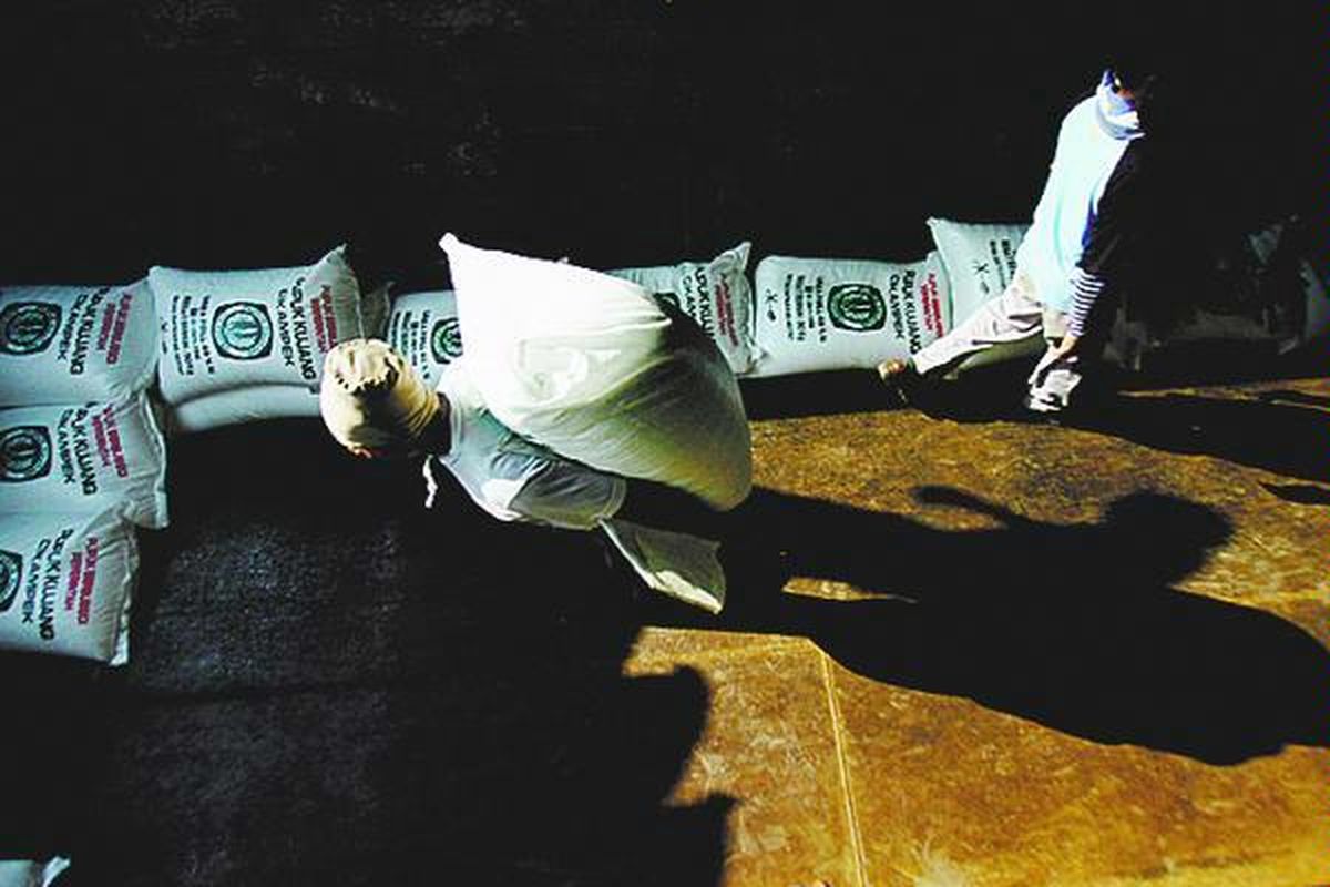 Buruh pikul mengangkut pupuk urea bersubsidi produksi Pupuk Kujang di Cikampek, Jawa Barat, beberapa waktu lalu. Pupuk Kujang memproduksi 3.200 ton pupuk urea per hari untuk menghadapi kebutuhan pupuk petani di Pulau Jawa.  