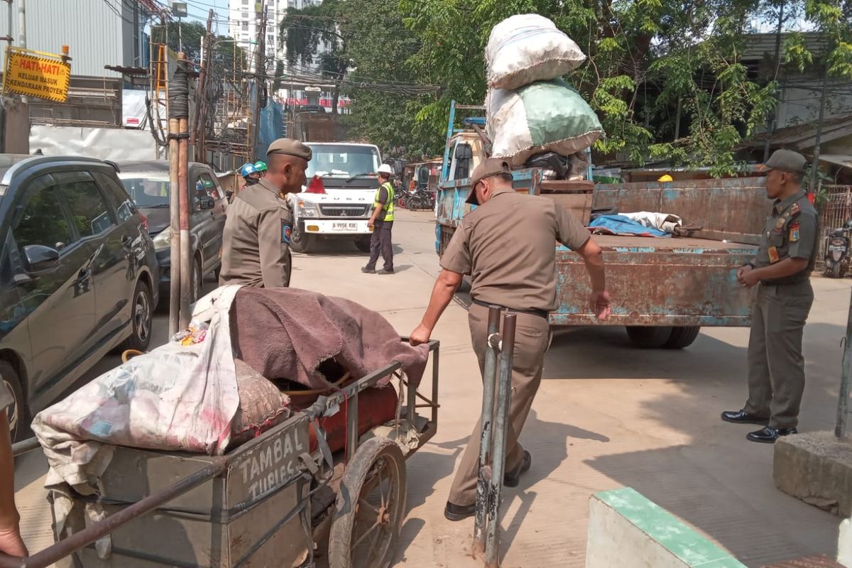 Satuan Polisi Pamong Praja (Sat Pol PP) menyita peralatan milik tukang tambal ban yang memangkal di pinggir Jalan Letjen MT Haryono, Bidara Cina, Jatinegara, Jakarta Timur, Senin (13/5/2024).