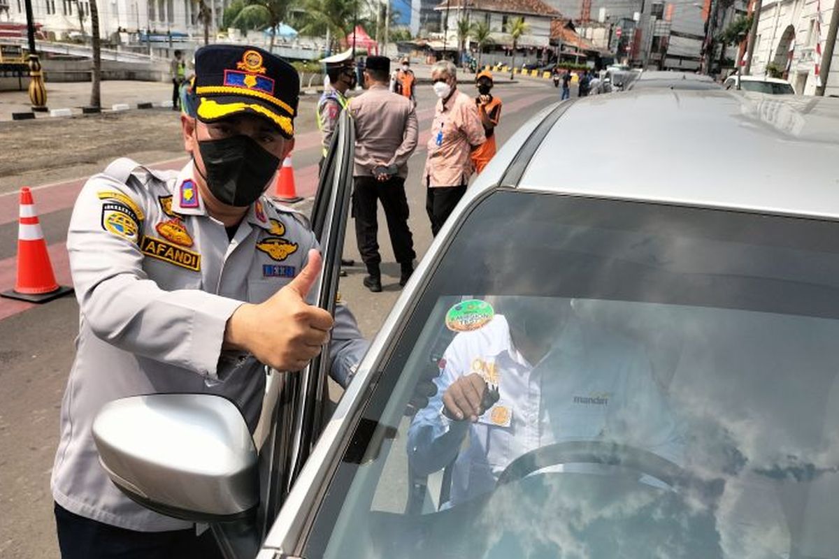 Kepala Seksi Operasional Suku Dinas Perhubungan Jakarta Barat, Affandi Nofrisal saat menempelkan stiker tanda lolos uji emisi di mobil kawasan Kota Tua Jakarta Barat, Kamis (25/8/2022).