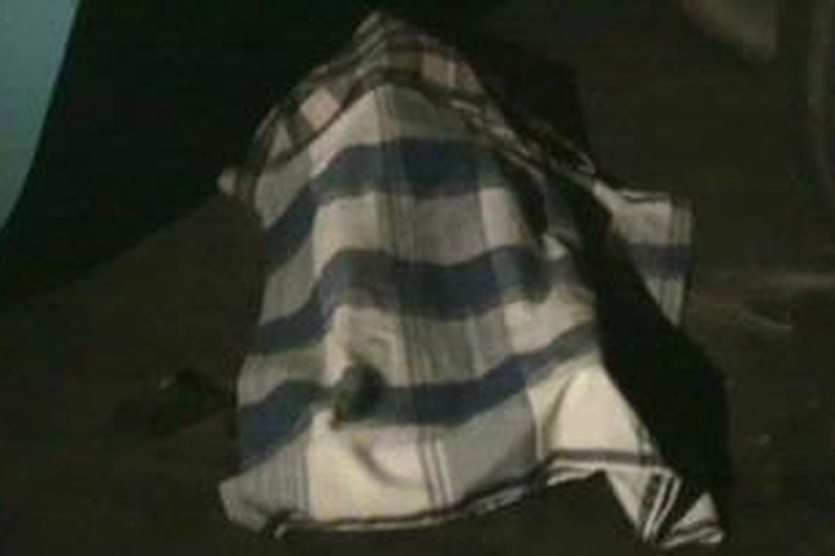 Jasad Herman (21) berada dibawah truk kontainer pengangkut alat berat telah ditutupi kain.