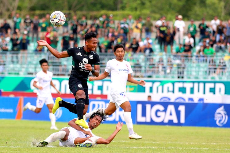 Pemain PSM Makassar Erwin Gutawa menghalau pemain Persebaya Surabaya saat pertandingan pekan ke-26 Liga 1 2022-2023 yang berakhir dengan skor 0-1 di Stadion Gelora Joko Samudro Gresik, Jumat (24/2/2023) sore.