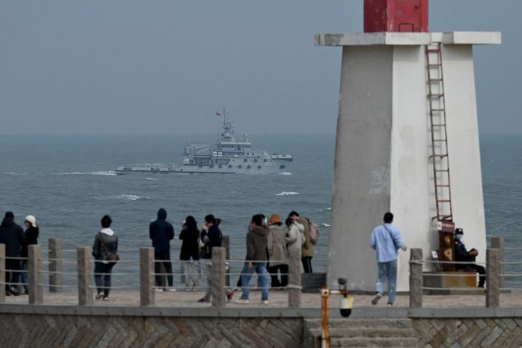 Kapal tunda Angkatan Laut PLA berlayar di Selat Taiwan, melewati turis di pulau Pingtan, titik terdekat ke Taiwan, di provinsi Fujian tenggara China pada 7 April 2023.