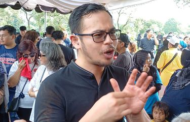 Anak ketiga almarhum aktor Ray Sahetapy, Surya Sahetapy berkomunikasi dengan bahasa isyarat usai pemakaman ayahnya di TPU Tanah Kusir, Jakarta Selatan, Jumat (4/4/2025).
